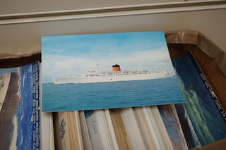 A box and two folders of postcards and a few cigarette cards, mainly relating to the Royal Mail Steam Packet Company and Royal Mail Lines Ltd., including a good quantity of 1930s and later postcards of cruise ships, many